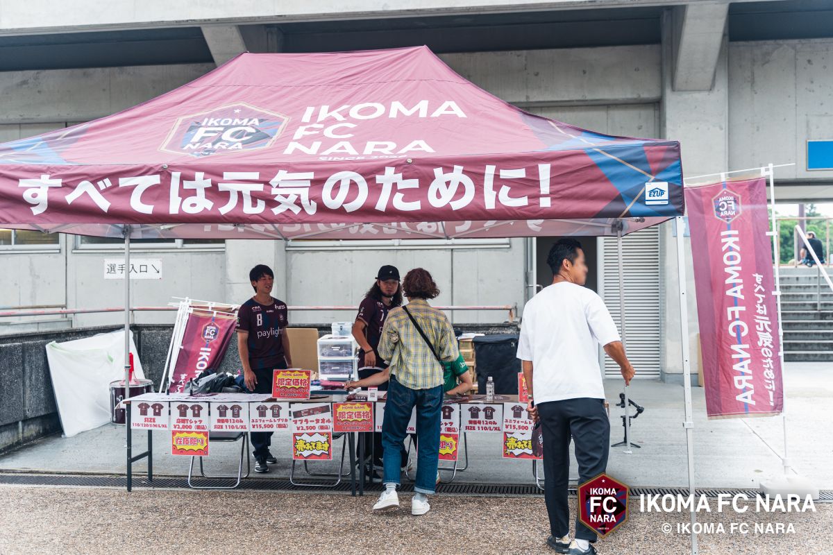 イージーアップテントデラックス（3×4.5m）アルミをブースにして接客する様子