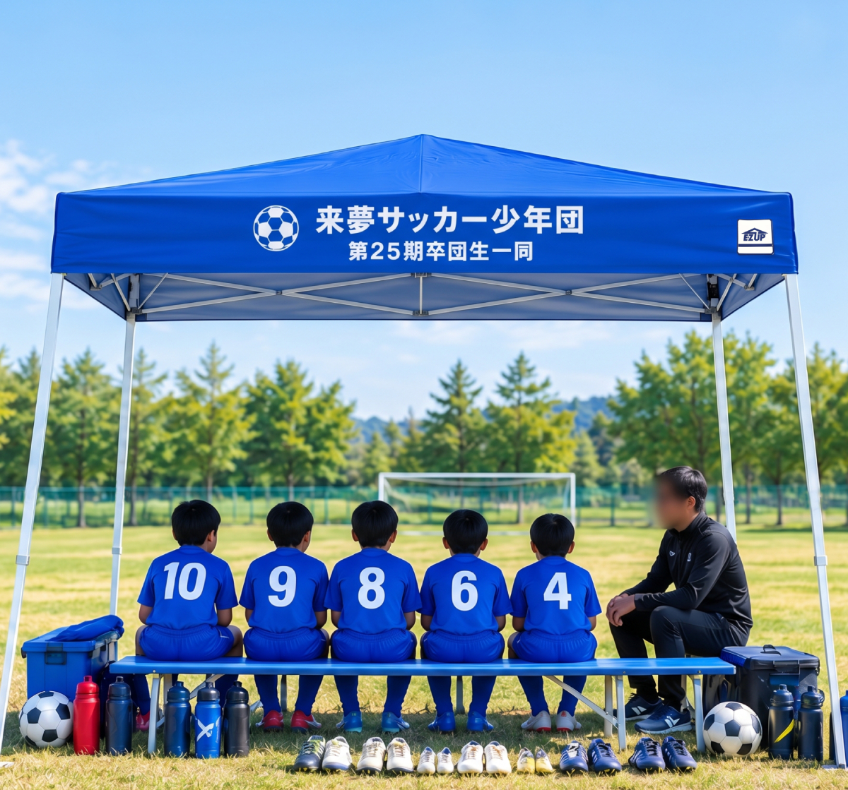 サッカー少年団の名入れテントで日除けをしている子供と指導者